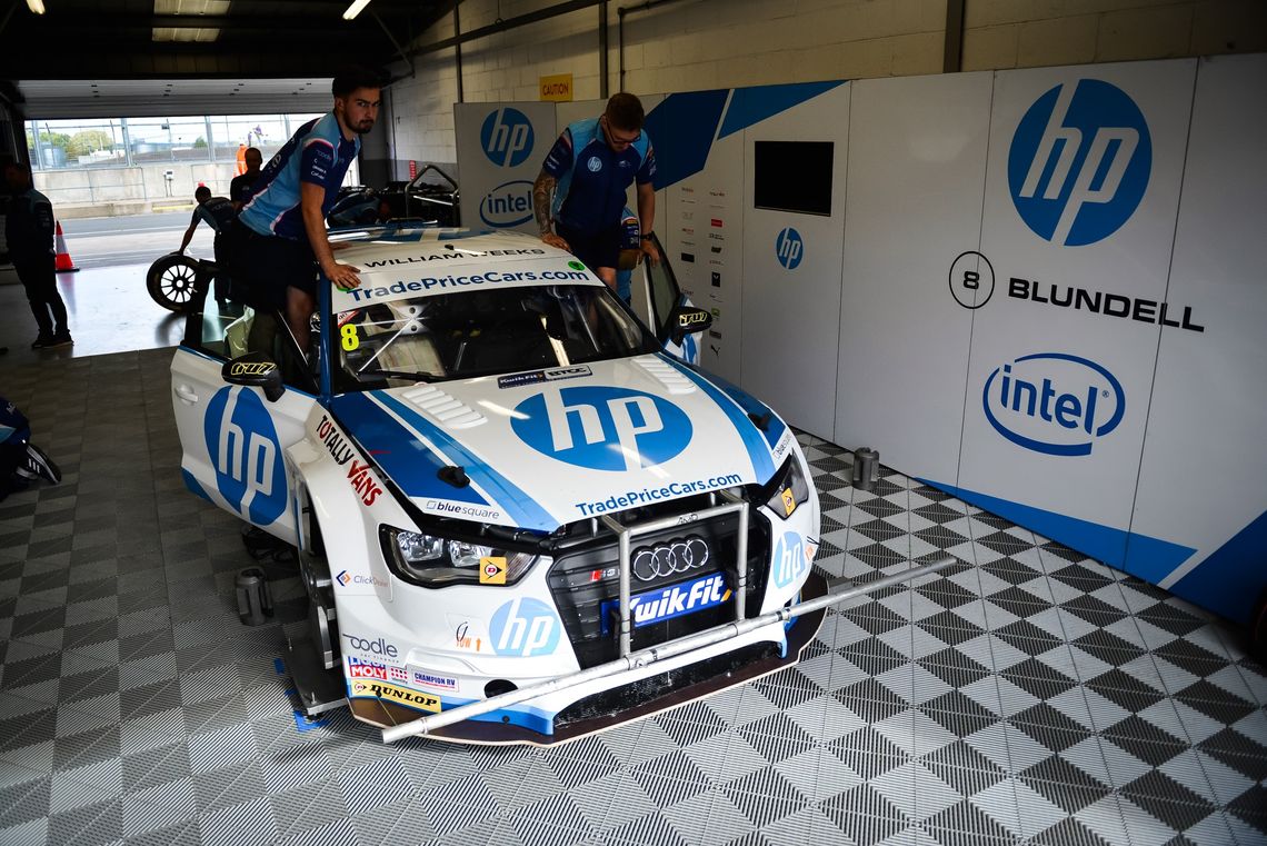 A BTCC Car in a garage, with printed pit walling