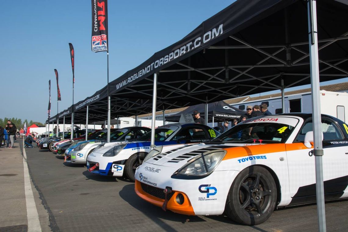 A series of Toyota MR2 cars beneath motorsport tents