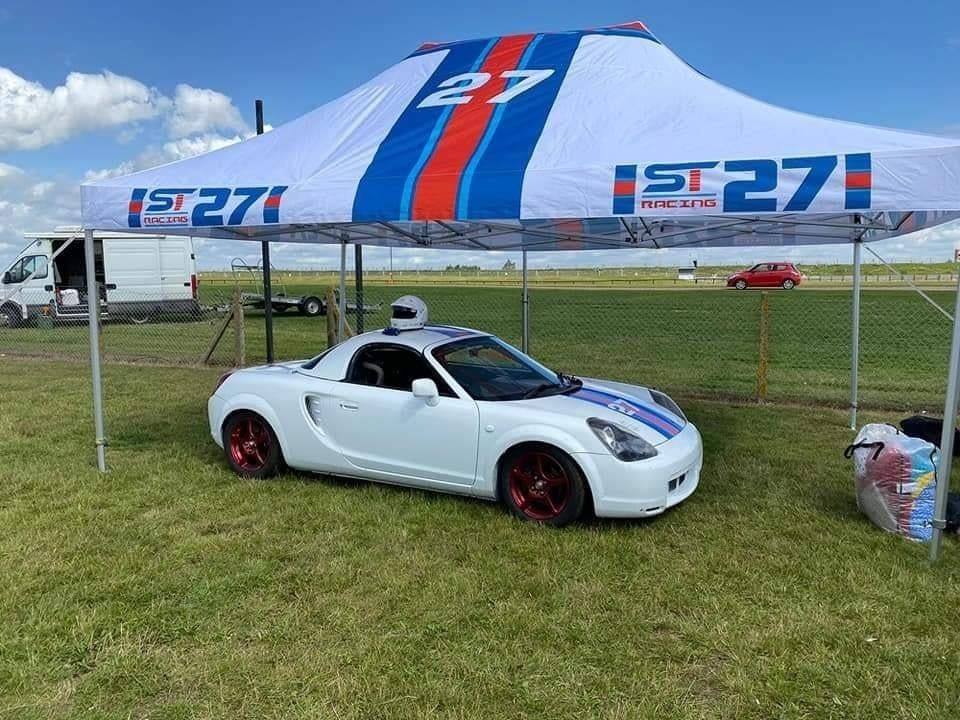 A race car beneath a branded race tent