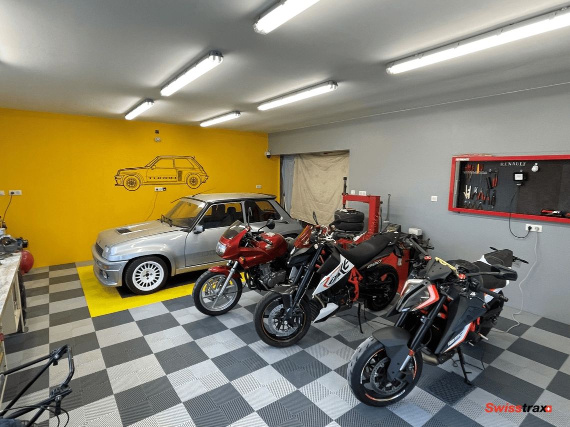 A series of motorcycles and car on swisstrax flooring in a home garage