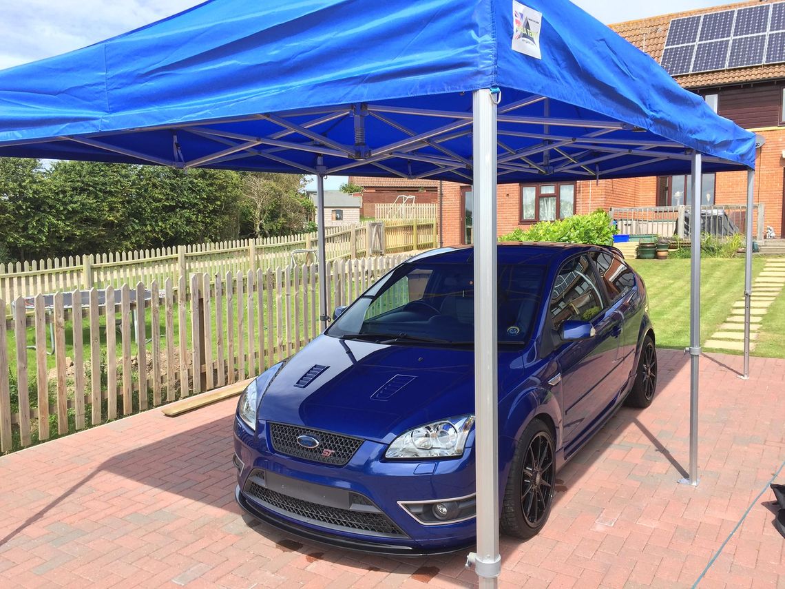 A vehicle beneath a blue gazebo